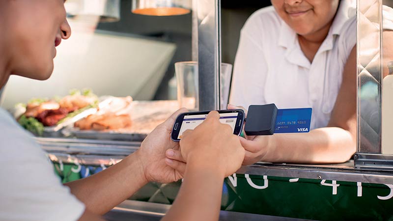Customer completing a transaction using a mobile credit card reader at a food truck.
