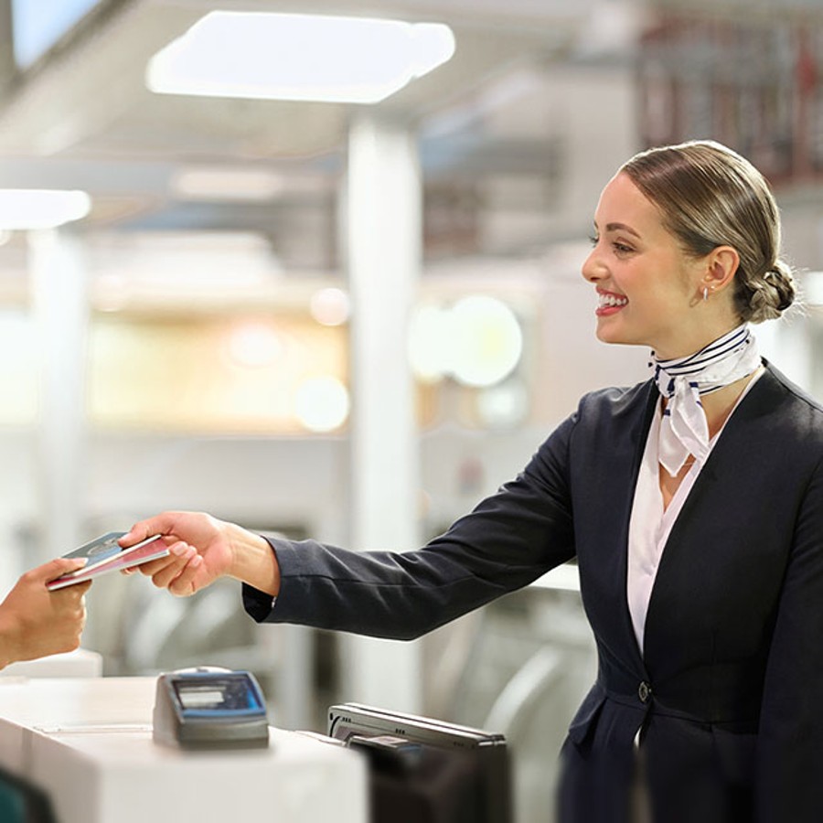 Woman smiling and handing passport to someone