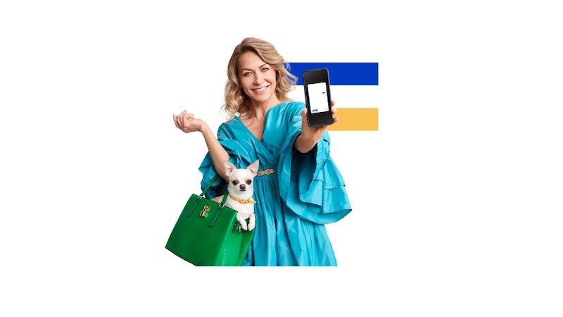 woman holding dog in handbag and phone