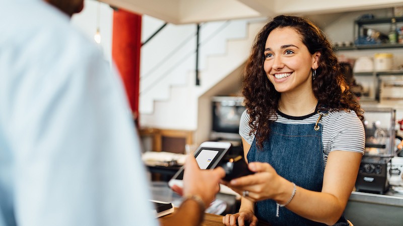 woman in shop taking mobile payment