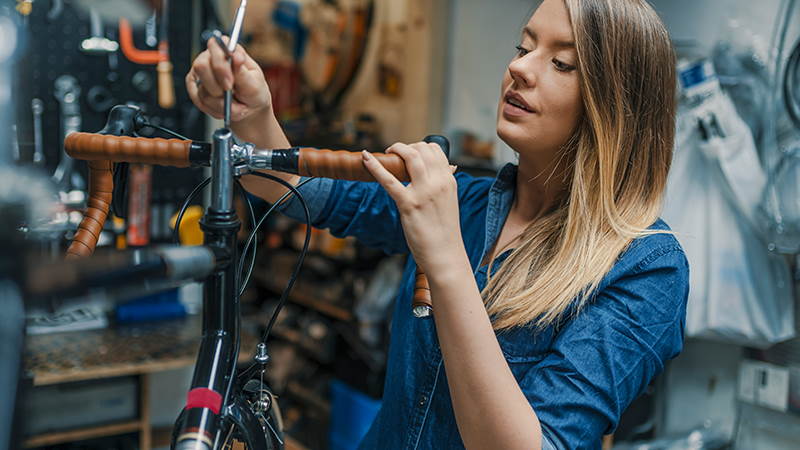 Woman repairing bike in bike shop
